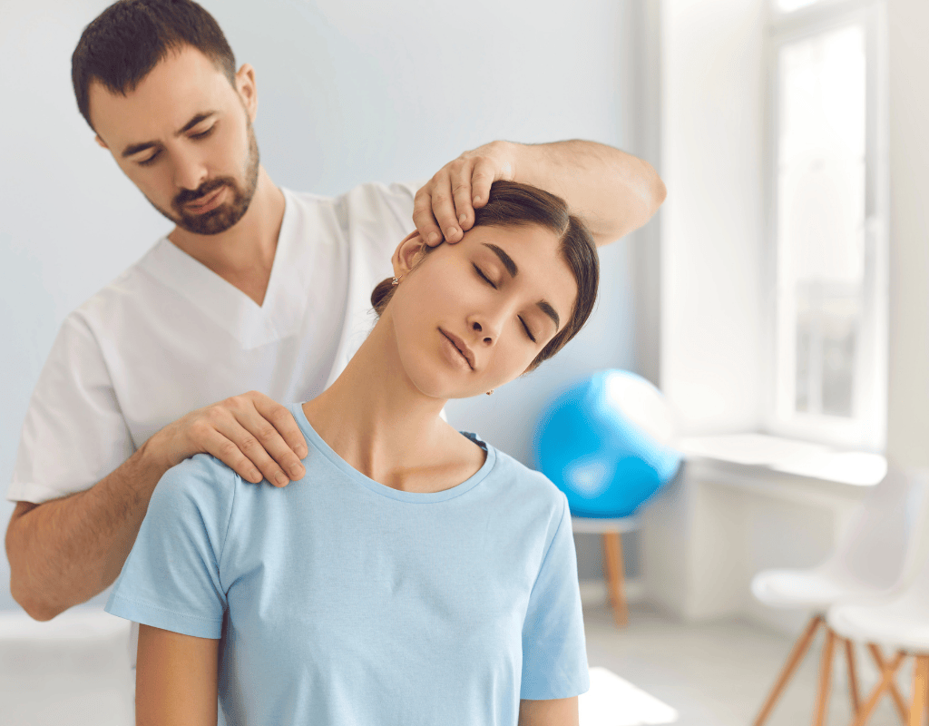 Therapist guiding a seated womans head into a side neck stretch with both hands