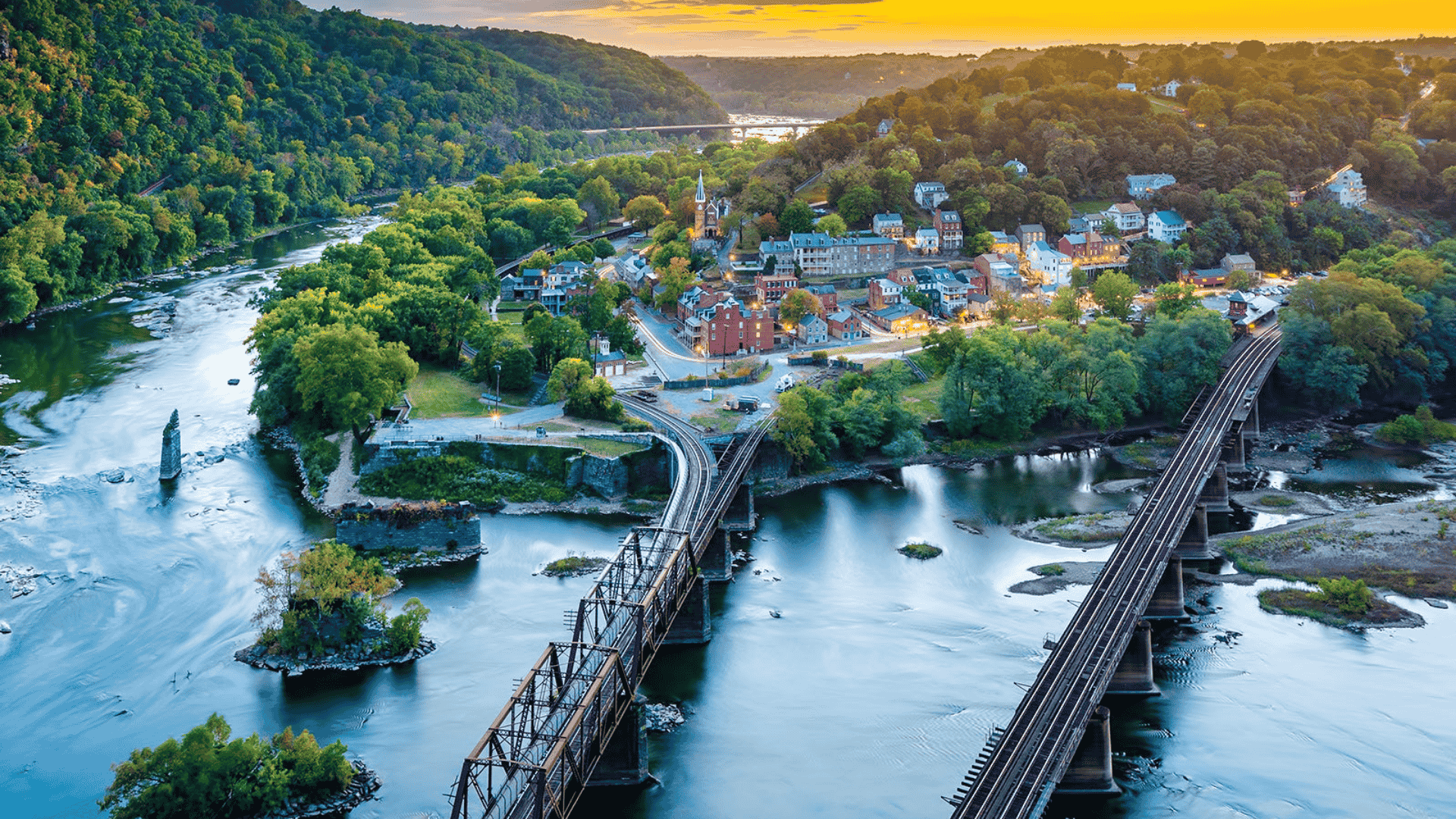 Aerial view of a West Virginia river town with bridges crossing the water between wooded hills
