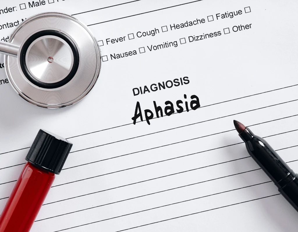Medical form with the word Aphasia written in the diagnosis field beside a stethoscope and a pen