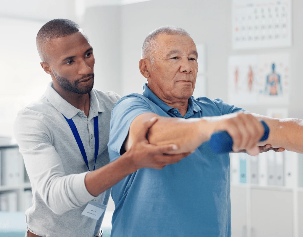 Therapist guiding an older man through a rotation exercise using a weighted bar held in both hands