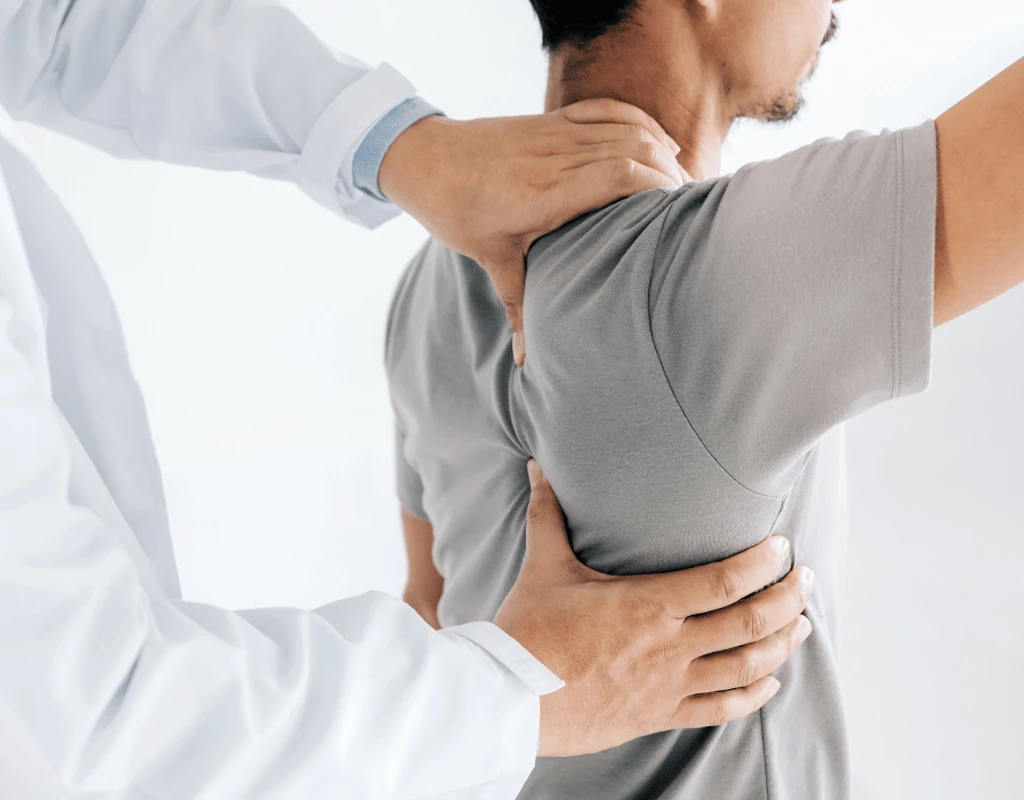 Close view of a clinicians hands placed on a patients neck and lower back