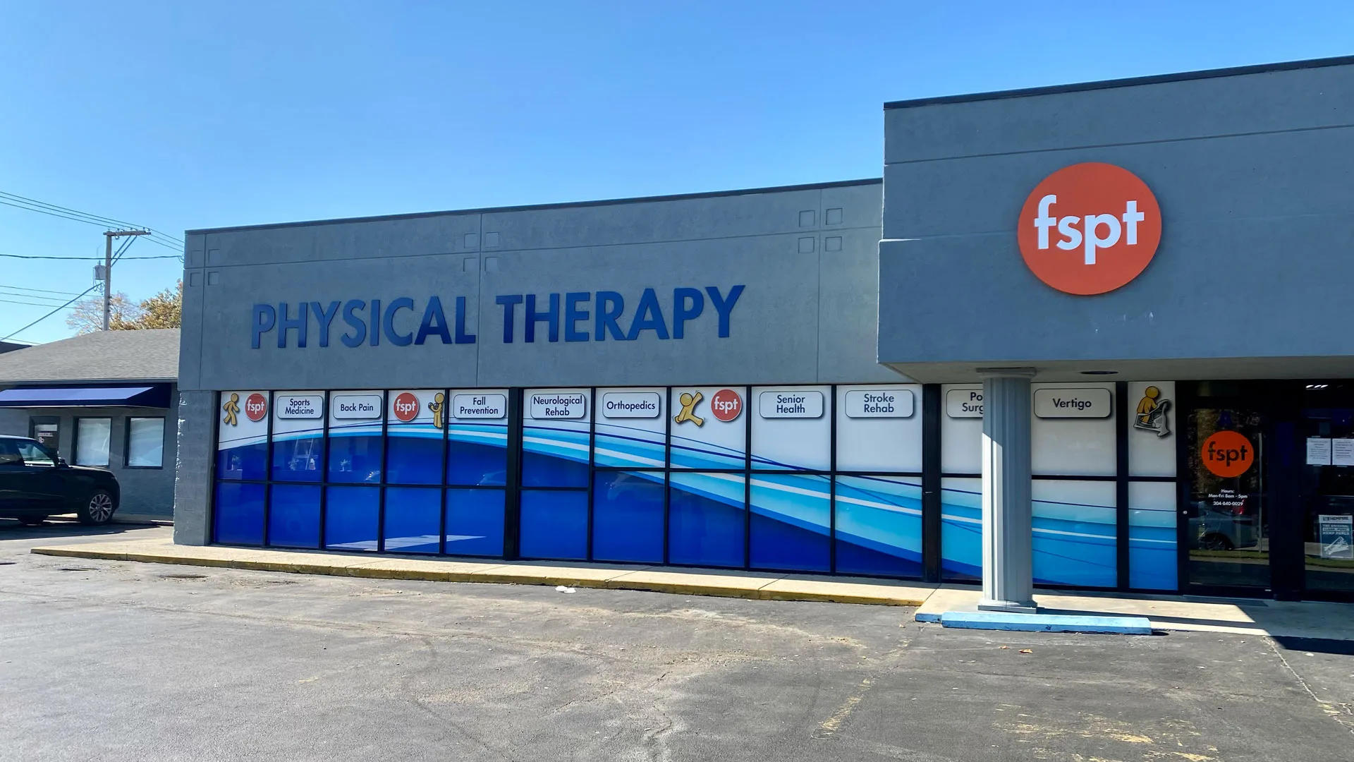 Blue building front with wave graphics, large PHYSICAL THERAPY lettering and the clinic logo on the corner