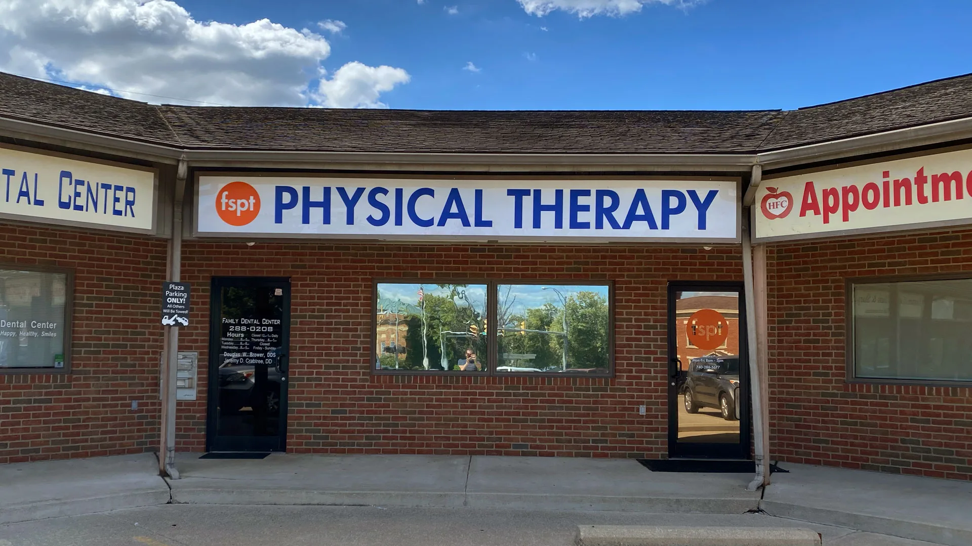 Brick storefront under an orange awning with PHYSICAL THERAPY and Appointments signage, sharing the building with a dental centre