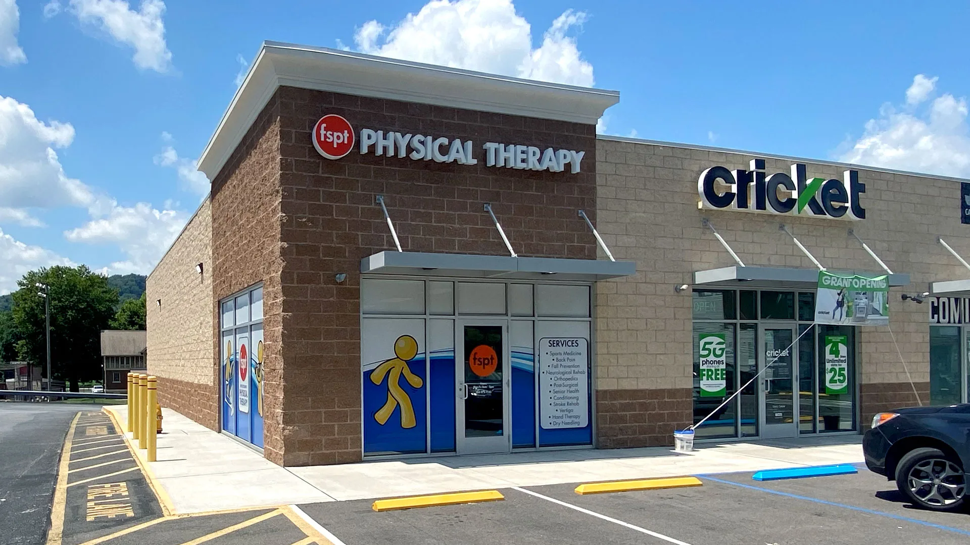 Brick building with a First Settlement Physical Therapy sign next to a Cricket Wireless storefront